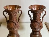 two brown vases sitting on a table next to each other