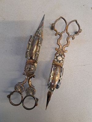 deux paires de ciseaux et une paire de ciseaux posés sur une table