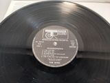 vinyl record on a white surface with a black label on it