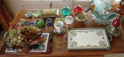 une table en bois sur laquelle sont posés de nombreux objets en verre