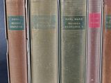 several old books are lined up in a row on a table