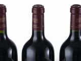 four bottles of wine are lined up on a table