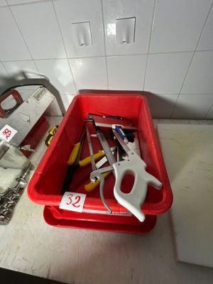 un bac rouge contenant des outils, posé sur un plan de travail