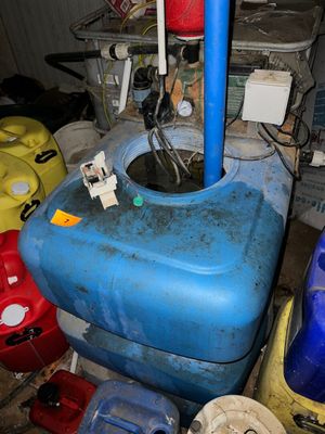 un réservoir d'eau bleu d'où sort un tuyau bleu
