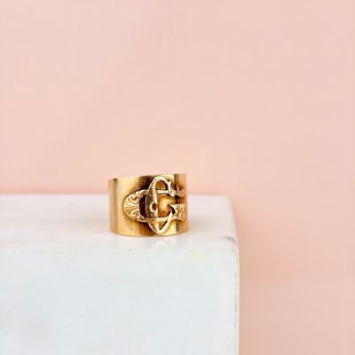 un gros plan d'une bague en or posée sur un bloc de marbre