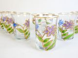 six glasses with flowers painted on them sitting on a white surface
