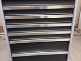 a close up of a metal tool cabinet on wheels in a garage