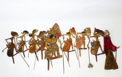 un groupe de figurines en bois posées sur une surface blanche