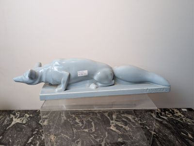 a blue statue of a dog laying on a table