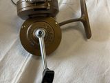 a fishing reel on a bed with a cell phone next to it