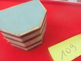 un plateau rouge sur lequel est posée une pile de quatre dessous de verre