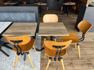 des tables et des chaises dans un restaurant au sol en bois et aux murs gris