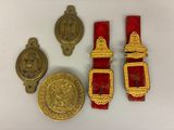 trois médailles d'or et une ceinture rouge sur un fond blanc