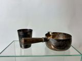 a glass table with a metal bowl and a wooden spoon on it