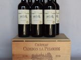 six bottles of wine are in a wooden box on a table