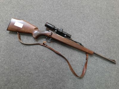 a rifle that is laying on the ground with a rifle on it