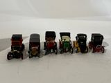 several toy cars are lined up in a row on a white surface