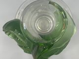 a glass vase with a green flower inside of it
