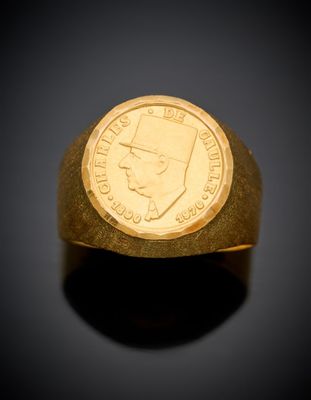 a close up of a gold ring with a coin on it