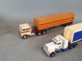 two toy trucks that are sitting next to each other