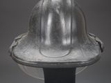 a close up of a metal helmet on a black stand