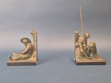 two bookends with a statue of a man and a woman sitting on a bench