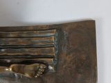 a bronze sculpture of a person holding a knife