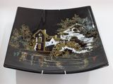 a black plate with a picture of a boat on it