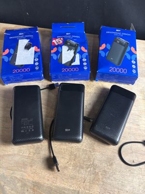 three black cell phones sitting on top of a table next to each other