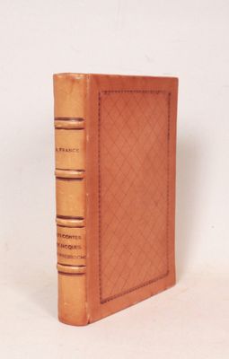 un livre en cuir marron posé sur une surface blanche