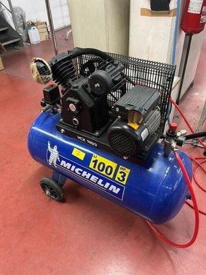 a blue air compressor sitting on top of a red floor