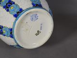 a white vase with blue and yellow designs on it