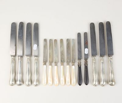 six silverplated knives and six knives on a white surface