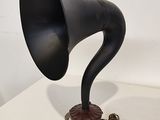 an old fashioned black gramphone on a stand with a cord