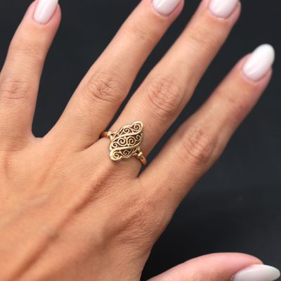 a woman ' s hand with white nails and a gold ring