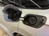 an electric car plugged in to a charging station with the door open
