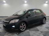 une photo d'une Toyota Auris noire garée sur un sol à damier