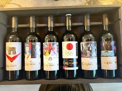 bottles of wine are lined up on a shelf in a wine shop
