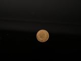 an image of a penny coin floating in the water on a black background