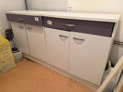 une armoire blanche avec des tiroirs violets dans la cuisine