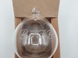 a glass ornament in a cardboard box with a white background