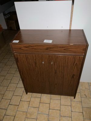 une armoire en bois avec un plateau blanc dans une pièce