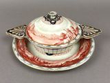 a white and red bowl and saucer on a saucer