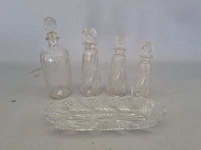 quatre bouteilles en verre et un plateau posés sur une table