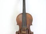 un vieux violon posé sur une surface blanche, près d'un mur blanc