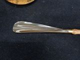 a glass spoon with a wooden handle next to a banana