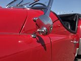 une photo d'une voiture rouge garée sur un parking