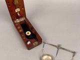a wooden case with two bells and a pair of scissors in it