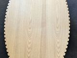 a round wooden cutting board on a black background