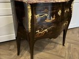 une commode noire et dorée avec un plateau en marbre